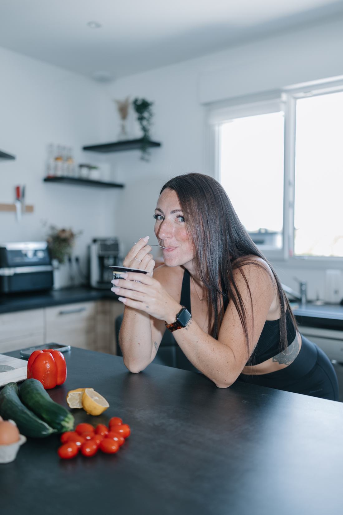 Clémence, fondatrice de NutriWell, savoure un yaourt dans sa cuisine